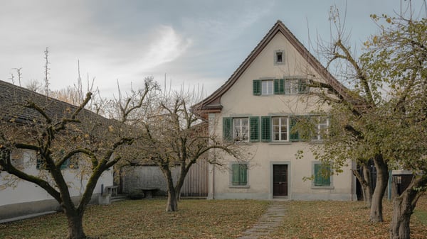 Familienhaus mit grünen Fensterläden in einem alten Obstgarten